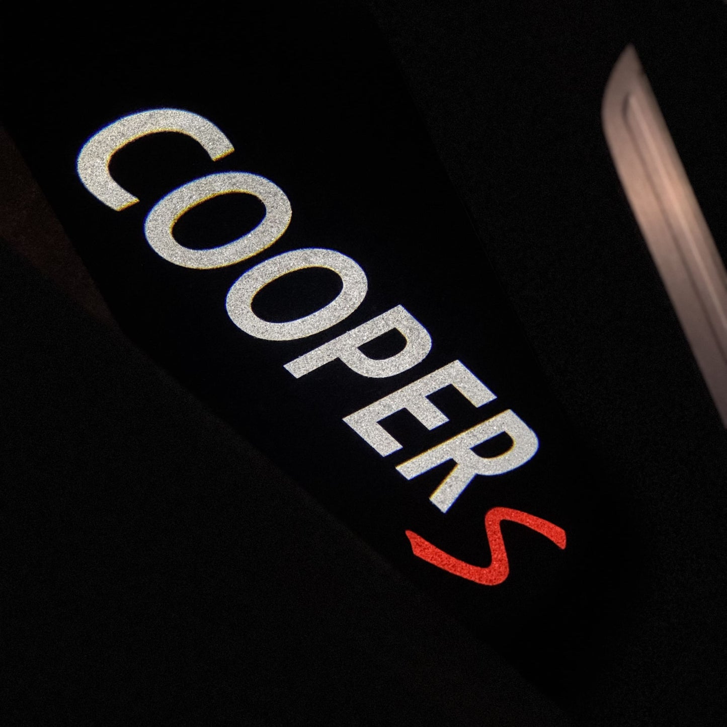 Cooper S puddle light illuminating pavement in red under MINI F56 Cooper S door