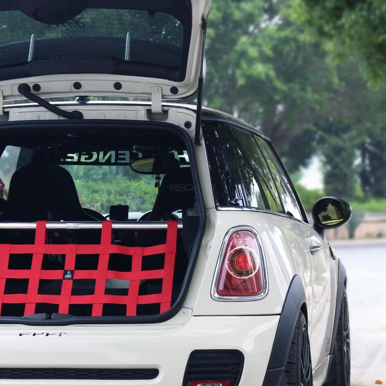 Red cargo racing net installed in a MINI Cooper R55, offering a bold and stylish storage solution.