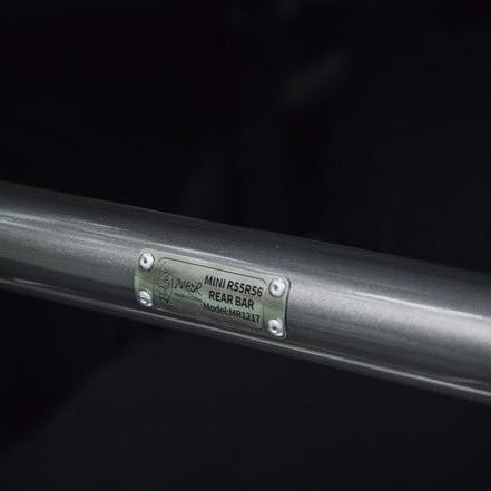 Close-up of the carbon steel rear strut brace, highlighting its precision engineering and sleek finish.
