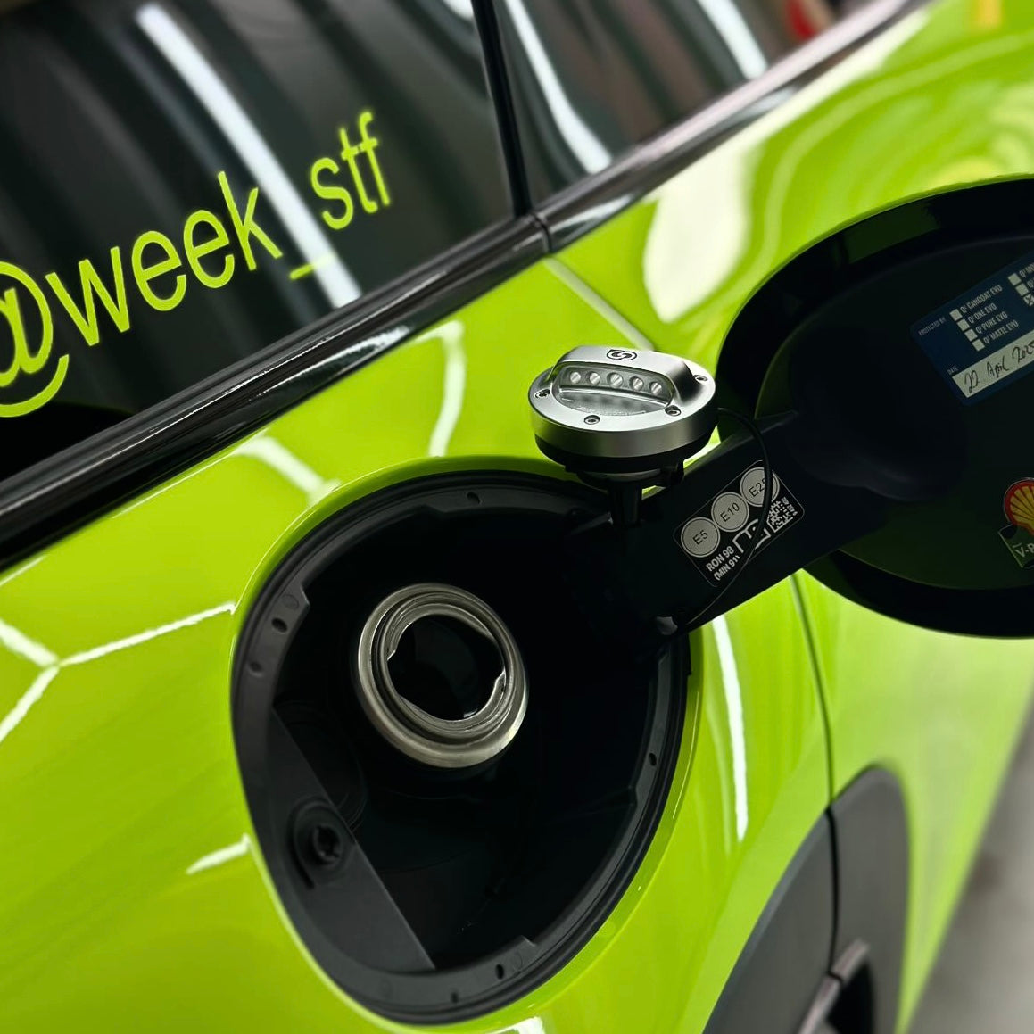 Side-by-side view of OneMiniBite Mini Cooper fuel cap on F54 Clubman, showcasing high-quality craftsmanship, anodized finish, and customer-fitted results from OneMiniBite reviews.