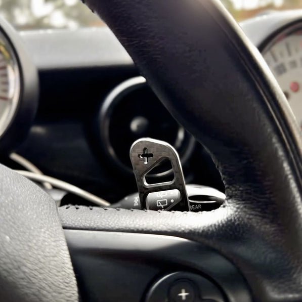 Detailed view of custom mini cooper part magnetic carbon fiber paddle shifter installed on a MINI Cooper R56 steering wheel