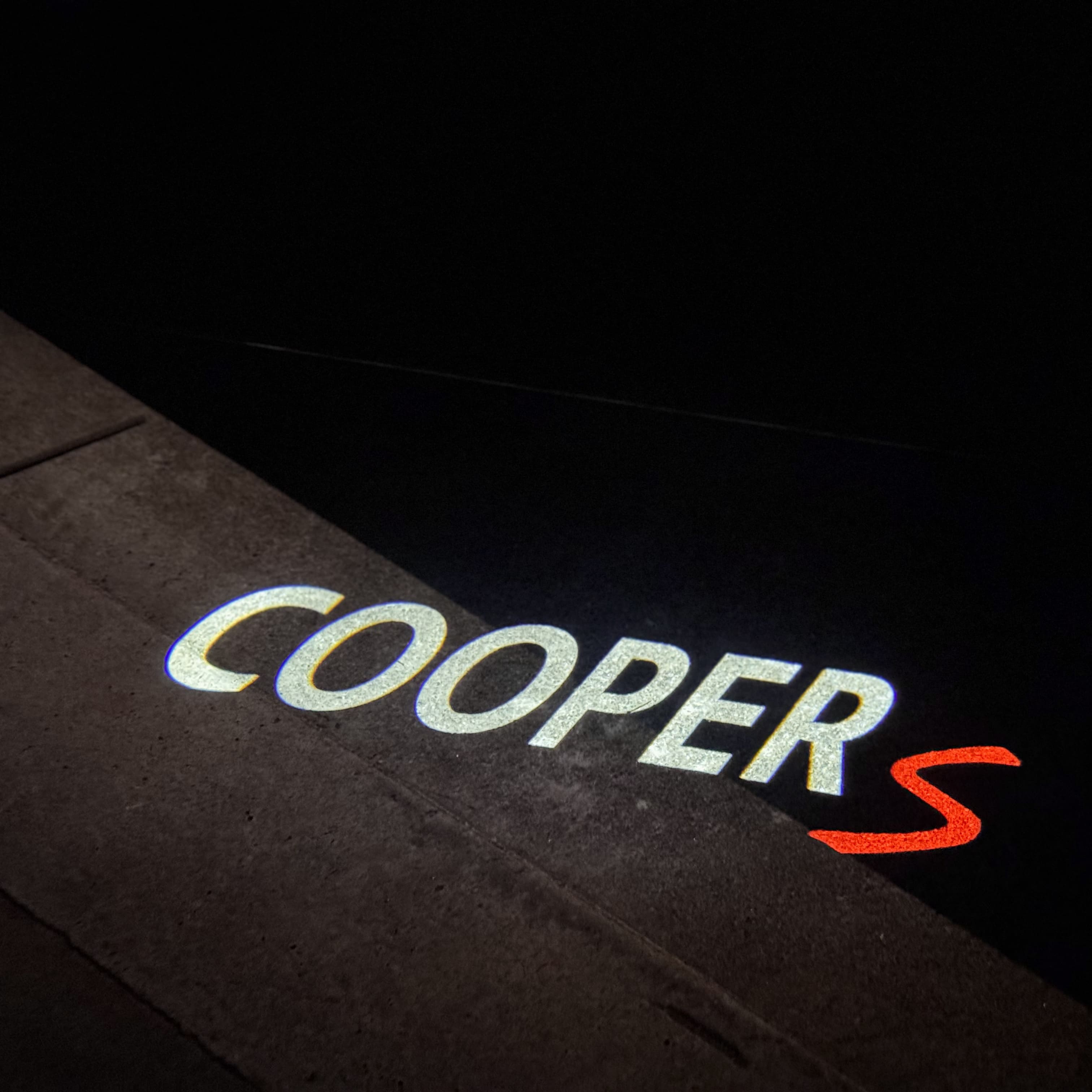 Cooper S puddle light glowing under open door of MINI F60 Countryman