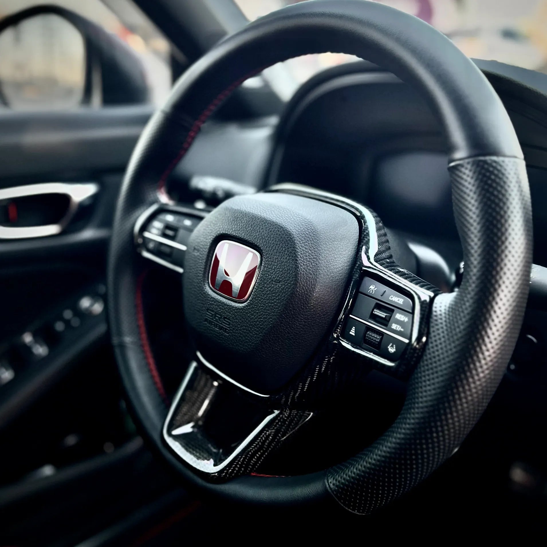Detail shot of gloss carbon steering trim overlay for Civic Type R FL5, real carbon fiber finish engineered for factory-like fit and visual harmony.