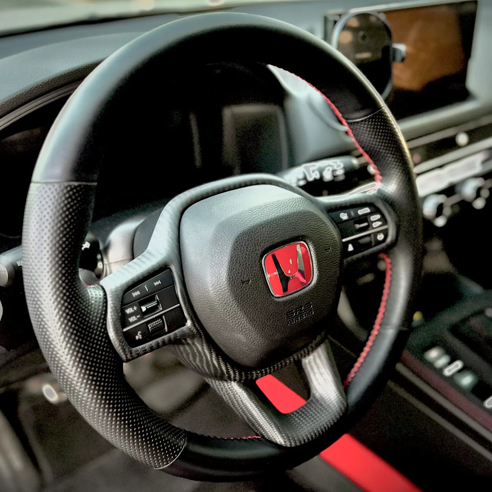 Close-up view of matte carbon steering trim overlay for Civic Type R FL5, precision-fit one-piece design preserving factory steering wheel proportions.