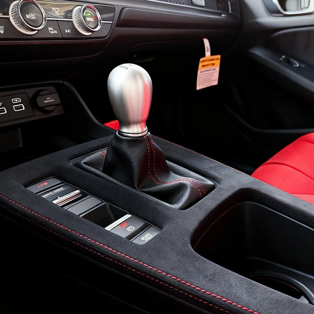 Close-up of Honda Civic XI FL5 Type R Alcantara shift panel console cover, hand-wrapped with precision stitching and custom embroidery options for LHD and RHD models.