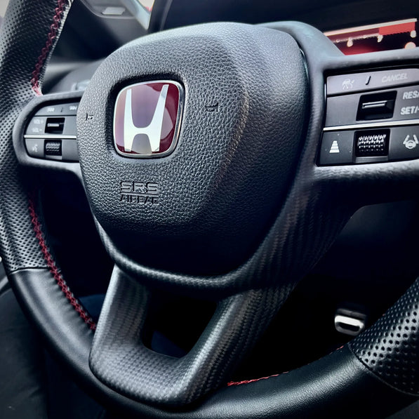 Matte carbon fiber steering wheel trim overlay installed on Honda Civic Type R FL5, adding a subtle OEM-style carbon accent without replacing factory components.