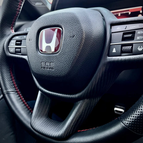 Matte carbon fiber steering wheel trim overlay installed on Honda Civic Type R FL5, adding a subtle OEM-style carbon accent without replacing factory components.