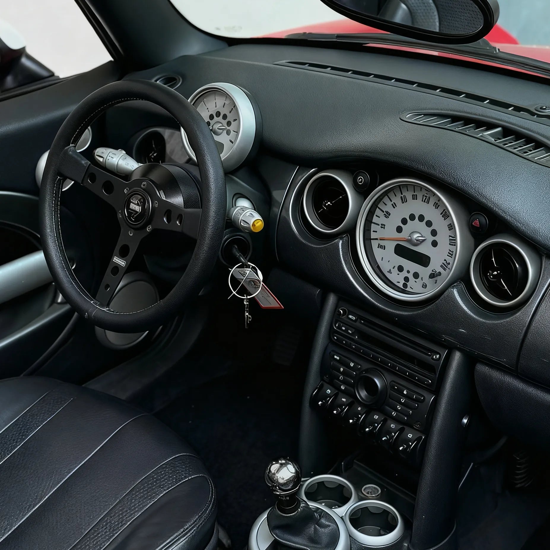 Installed view of MINI Cooper R53 steering wheel hub adaptor showing seamless fitment with aftermarket steering wheel and factory-style finish inside Gen 1 MINI interior.