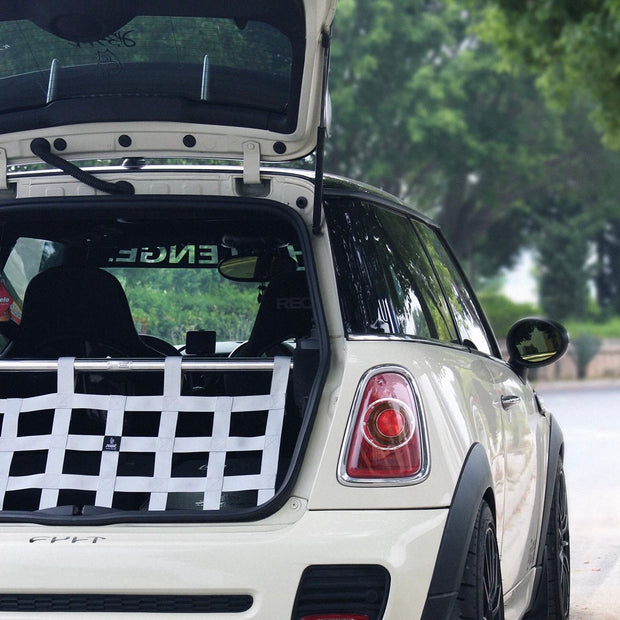 White cargo racing net installed in a MINI Cooper R56, showcasing its sleek design and secure fit.