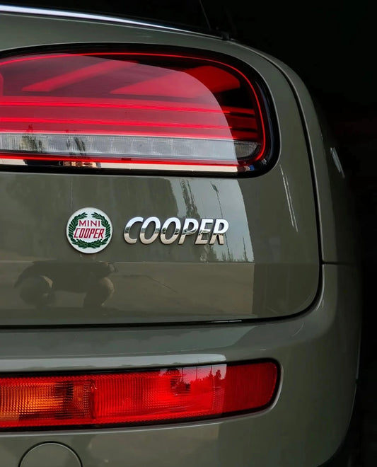 Laurel enamel badge installed on the rear hatch of a MINI Cooper Clubman, showcasing vintage rally style.