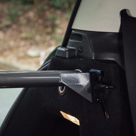 Angled view of the rear strut brace installed in a MINI Cooper, showcasing its innovative locking mechanism.