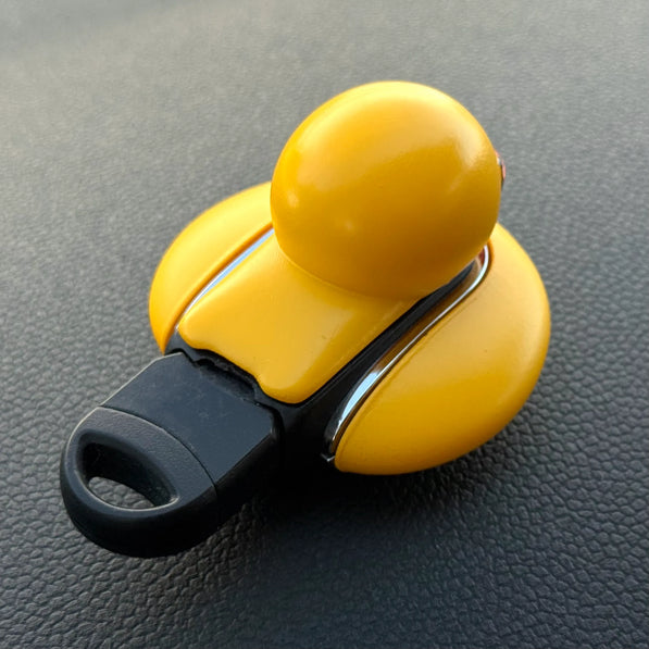 Flat lay of handmade yellow duck MINI Cooper keyfob cover for F54, F55, F56, F57, F60, slim and durable design.