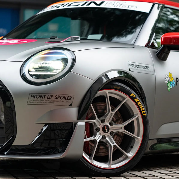 Side view of MINI J01 Cooper Electric with carbon fiber side skirts and mirror caps