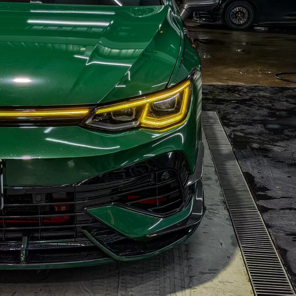 VW Golf MK8 R front bumper canards installed, gloss carbon fiber — driver side view
