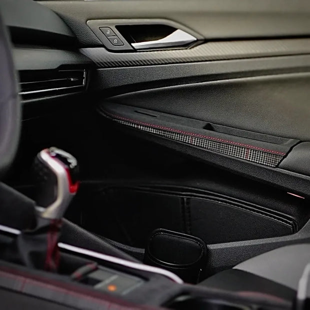 Overlay-style door control panel cover installed on a VW Golf Mk8 GTI, showing OEM-aligned fitment, extended switch cutouts, and a plaid semi-rough leather finish designed for daily use.