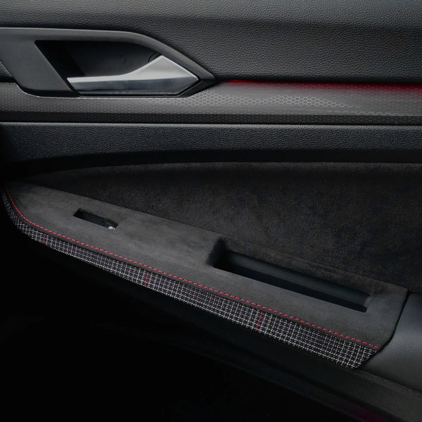 Door control panel cover installed on a Volkswagen Golf Mk8 GTI, protecting the factory door switch area with a plaid semi-rough leather overlay designed to prevent scratches and wear.