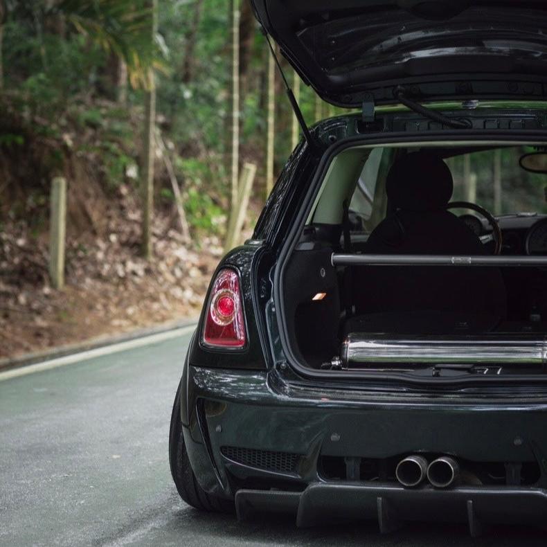 Rear view of the Carbon Steel Rear Strut Bar installed in a Mini Cooper R55, showcasing its integration with the vehicle’s interior.