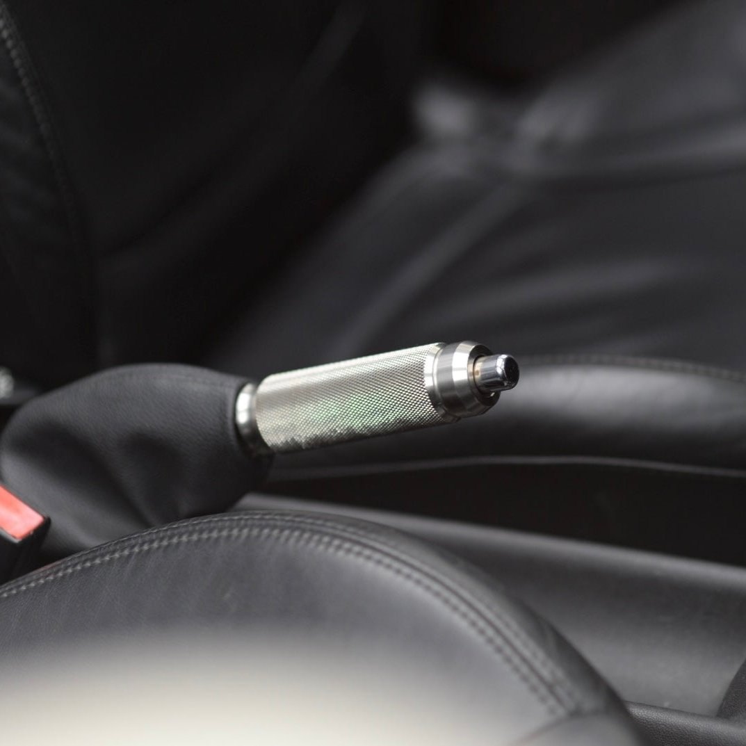 Close-up view of the handbrake lever in a Mini Cooper, highlighting the premium finish and stylish upgrade to the car's interior.