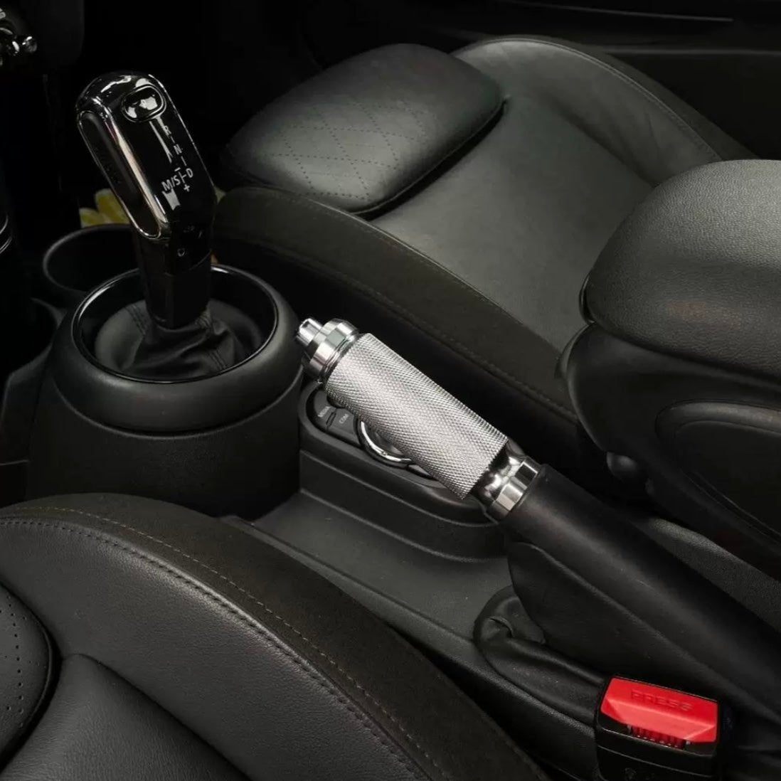 Installed aluminum handbrake lever in a Mini Cooper interior, showcasing a sleek design and enhanced functionality.