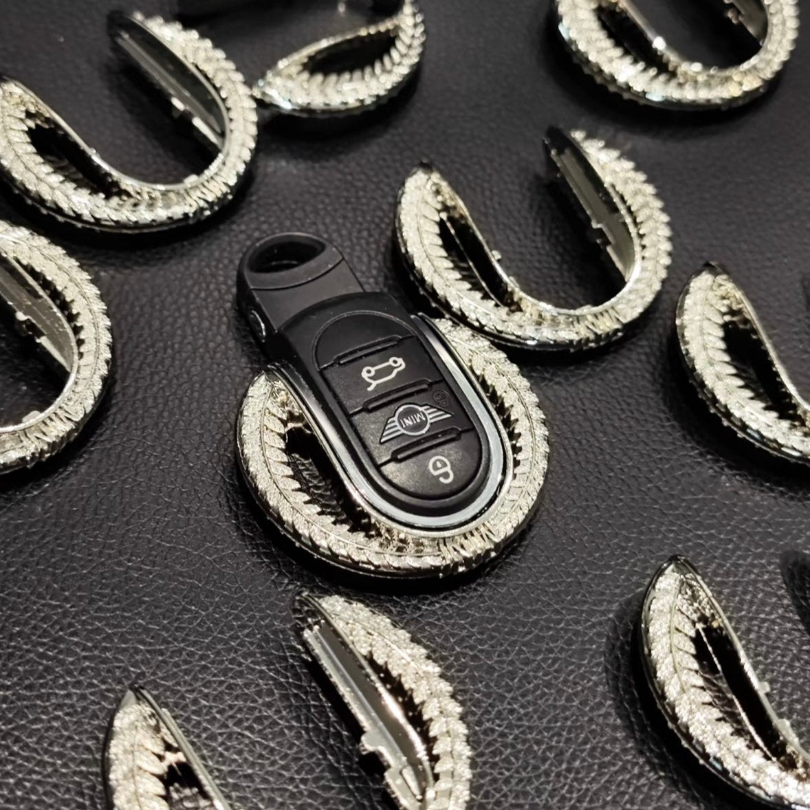 Close-up of the alloy keyfob shell keychain for Mini Cooper, highlighting its weighty texture and premium alloy material in production line