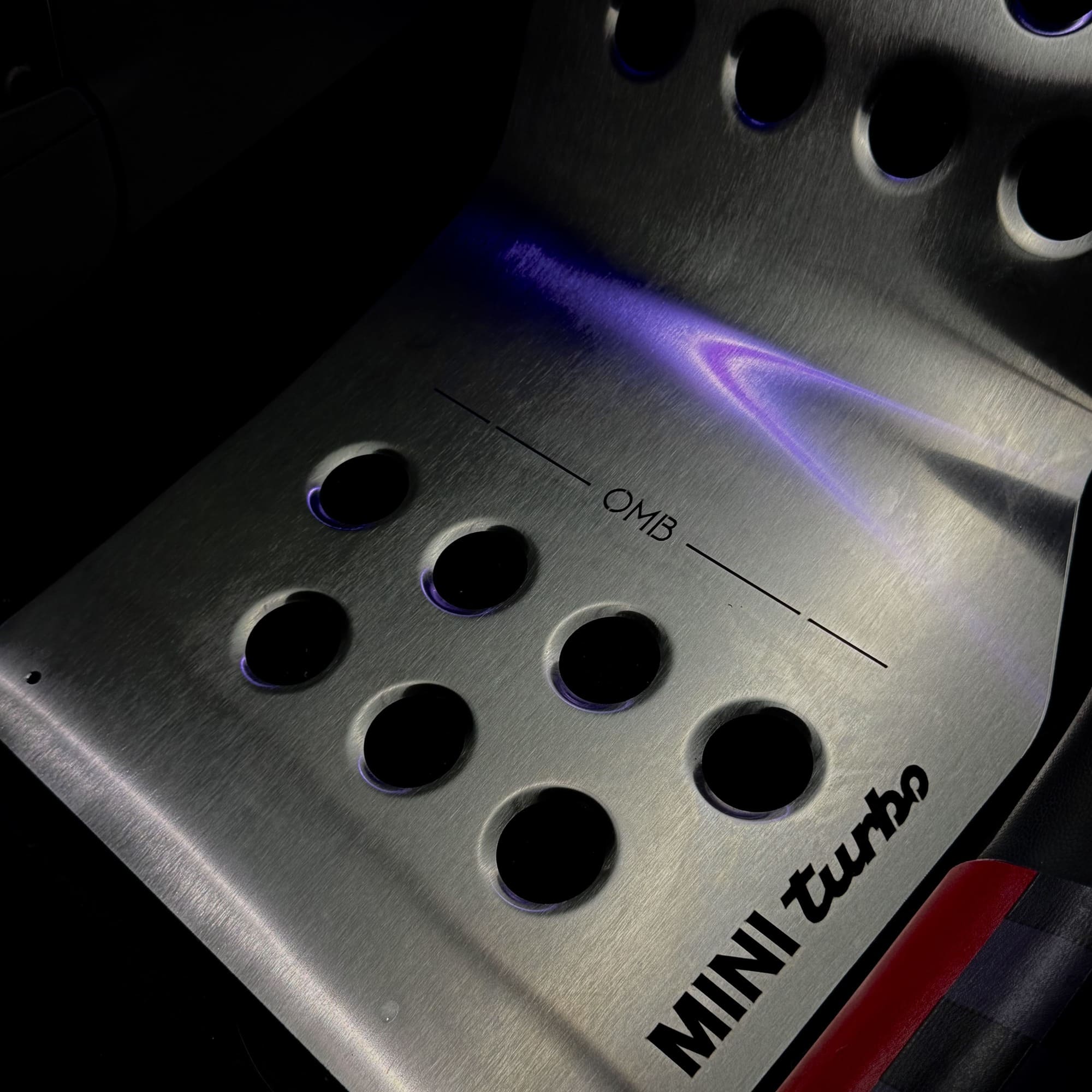 aluminum Stainless steel track mat installed in MINI Cooper footwell, covered by OEM rubber floor mat